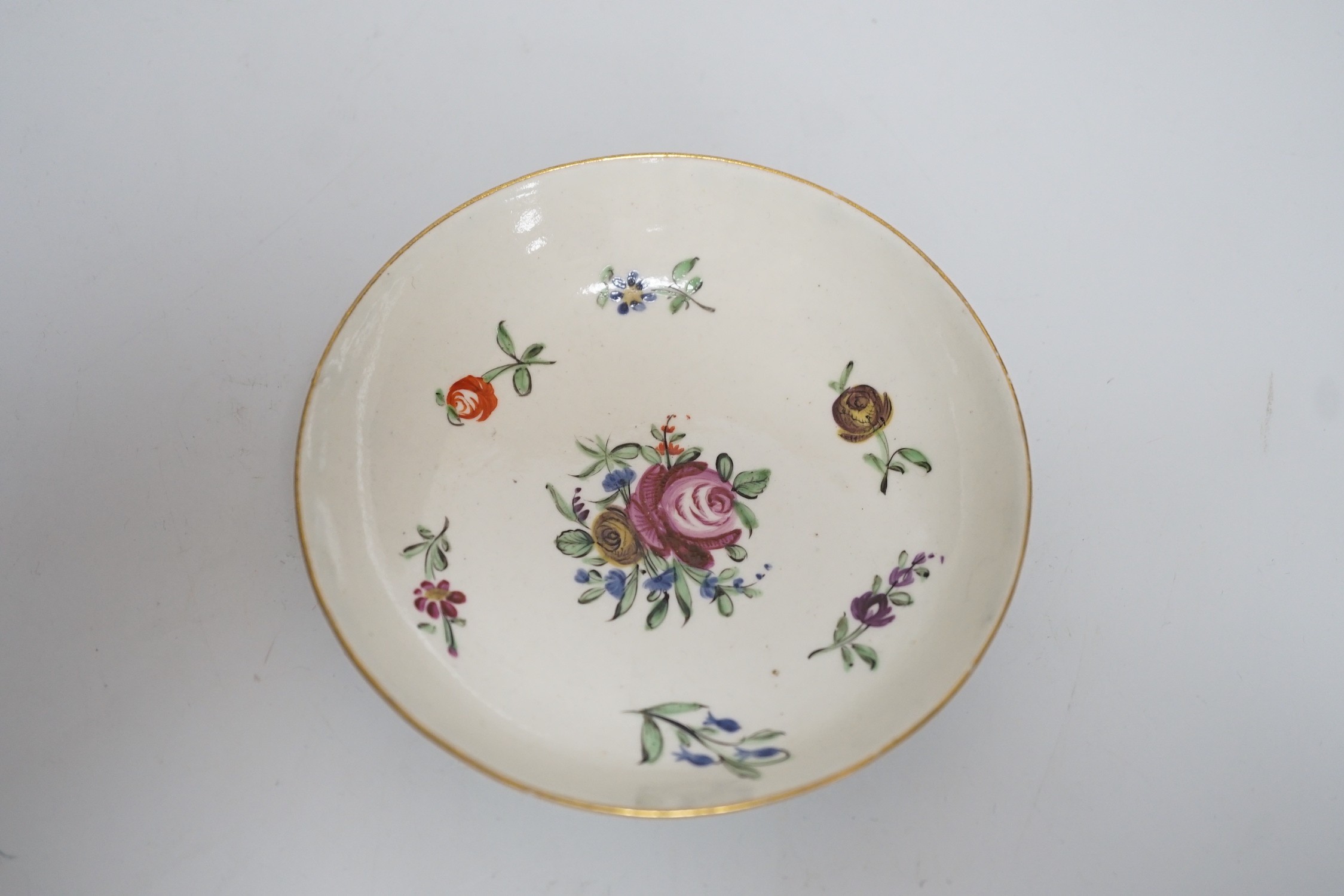 An 18th century Caughley teabowl and saucer, with back to back roses, saucer 12.5cms diameter